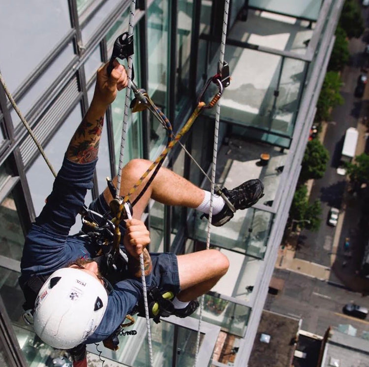 Rope access technician performing exterior building maintenance in Toronto